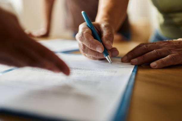 Close up of unrecognizable person signing a contract in the office. signing paper